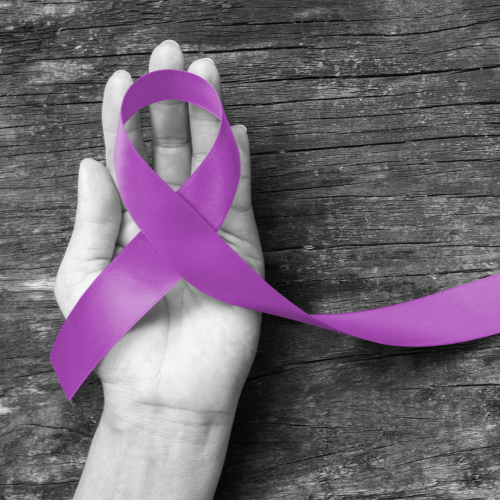 A hand holding an Alzheimer's awareness ribbon
